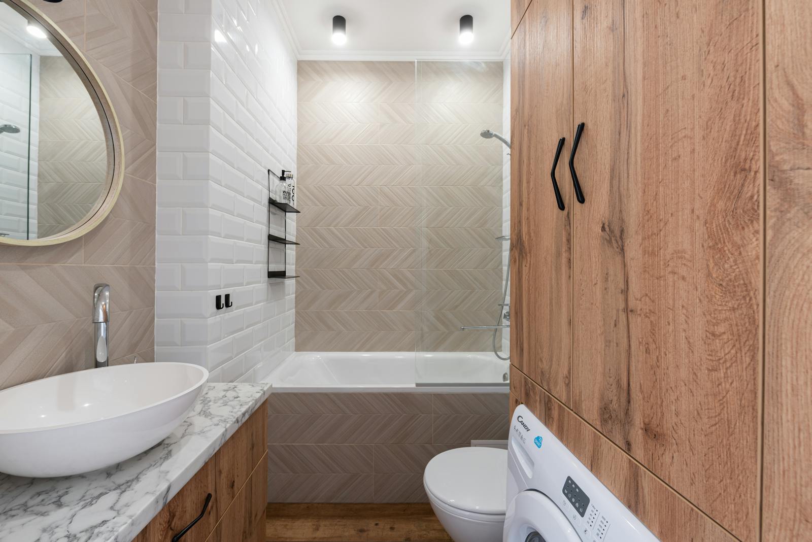 A sleek, contemporary bathroom design featuring a wooden cabinet, white fixtures, and modern lighting.